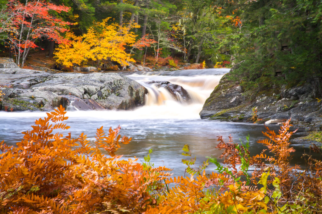 Silky waterfall on the Mersey River in Kejimkujik National Park surrounded by fall foliage Nova Scotia